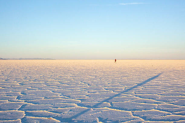 Silhouette of a happy couple jumping on the amazing mirror effect of Uyuni Salt Flats against sunset sky, Bolivia, South America, ( Self Portrait )