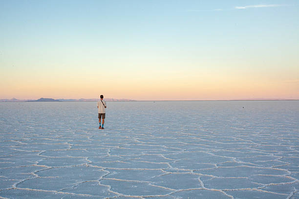 Photographer explores great salt flat at sunset, Great Salt Lake Desert, Utah