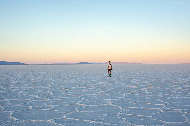 Photographer explores great salt flat at sunset, Great Salt Lake Desert, Utah