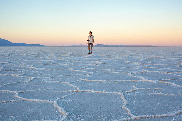 istock Photographer explores great salt flat at sunset 2218521479