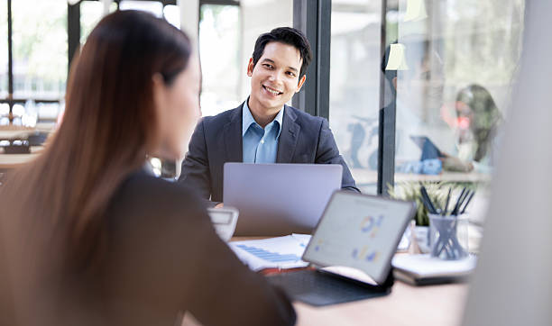istock Smiling business people working on laptop while sitting at co workspace 2218522473