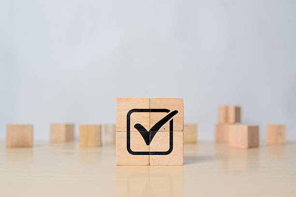 istock Check mark icon on wooden cubes representing service quality, ISO standards, compliance, and approval process in corporate management 2218522622