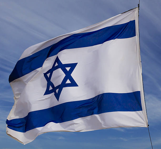 istock Israel flag in the wind isolated against the sky 2218524254