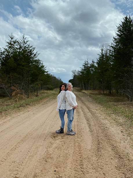 istock Two women standing back-to-back on a country road 2218525340