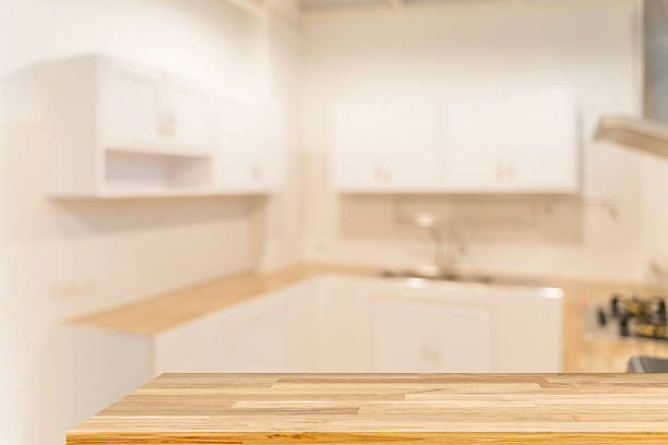 Wood tabletop on blurred modern kitchen interior background, empty counter mockup for product display design