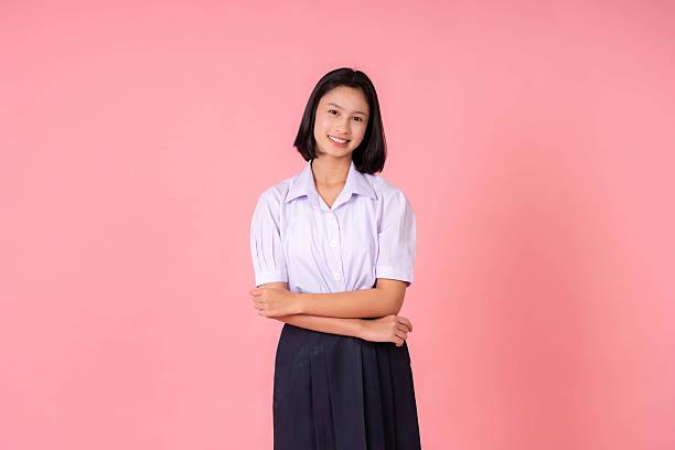 istock Inside a pink background studio, a cute Asian school girl smiled brightly while posing with her graduation cap, celebrating the power of education and her acceptance into a top university. 2218529091