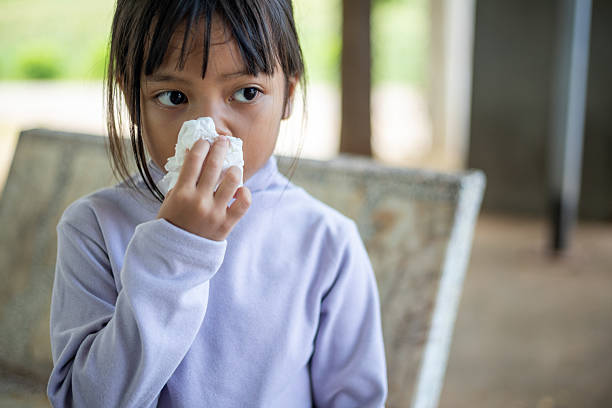 istock A young girl is sitting on a bench with a tissue in her hand 2218529389