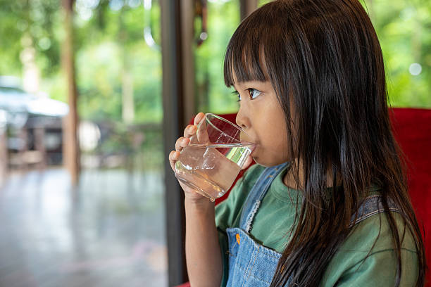 istock A young girl drinking water from a glass 2218529417