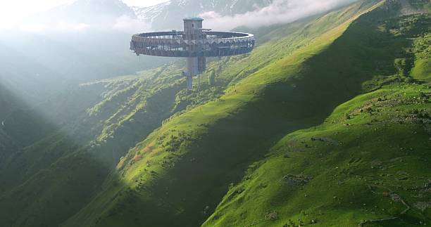 istock This photo shows a brightly lit alien ship hovering low over lush green hills in broad daylight. 2218536435