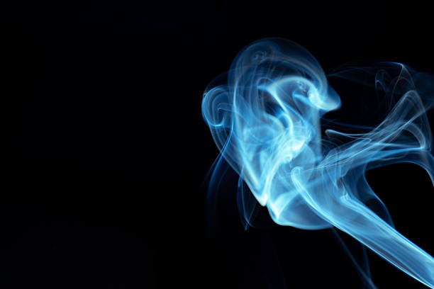 Abstract representation of a figure in motion created with smoke against a blue background.