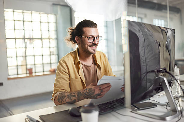 istock Happy businessman working on reports and PC at corporate office. 2218537214