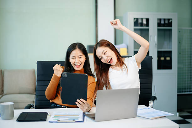 istock wo business women using laptop, standing and talking about analyzing documents in Teamwork Finance, Marketing 2218538260