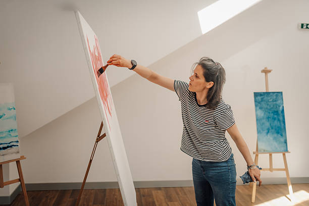 istock Female artist painting on large canvas in studio 2218539091