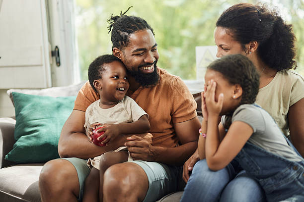 istock Happy black family talking on sofa at home. 2218539195