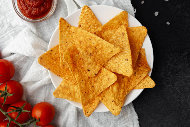 istock Nachos with fresh tomatoes, salsa and salt on white cloth over dark background 2218543435