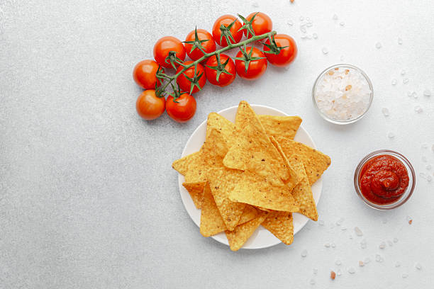 istock Crispy nachos with tomatoes, salsa and salt on white background 2218543439