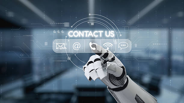 istock Futuristic robotic hand interacting with digital contact options on a transparent touchscreen in a modern office environment. Auvana 2218543484