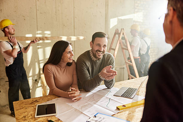 istock Happy couple talking to their agent at construction site. 2218547698