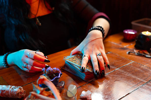 istock Fortune teller reading tarot cards on a wooden table with esoteric items 2218550722