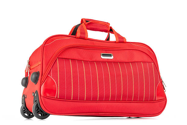 istock Bright red wheeled travel bag with side handles and front pocket. Studio shot isolated on white background. File contains a path to isolation. 2218552856