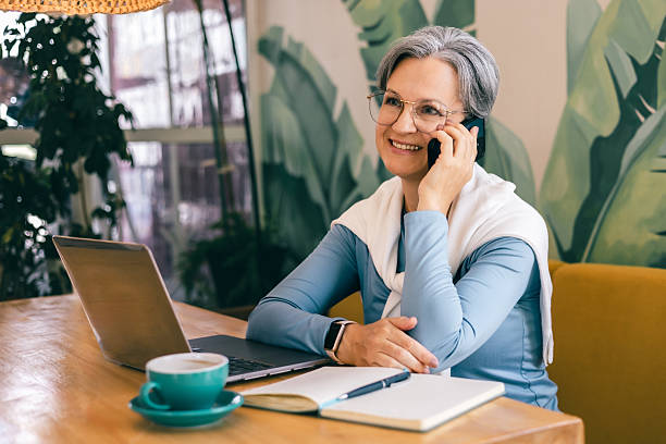 istock Confident mature woman smiling during phone conversation in modern workspace 2218554253