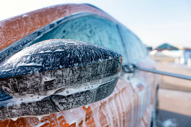 Hand washing car with pink foam, advertising.