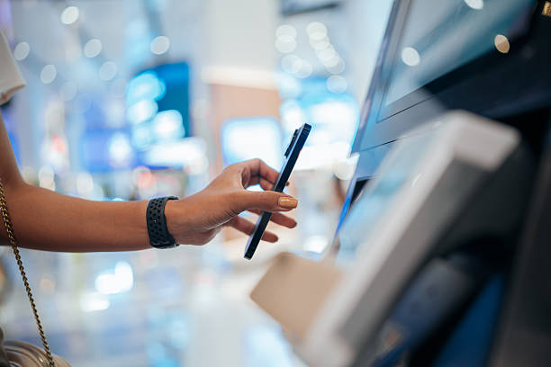 istock Close-up of woman’s hand using smartphone at digital self-service payment kiosk 2218556503