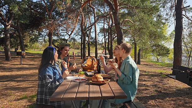 istock Friends Enjoy Outdoor Picnic in Sunny Forest Setting 2218558041