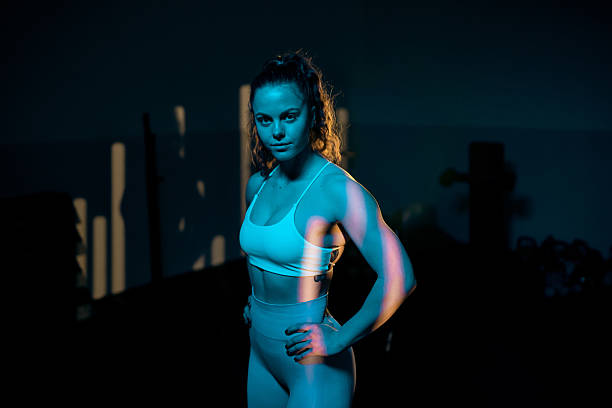 istock Young sportswoman stands strong under dramatic lighting 2218558126