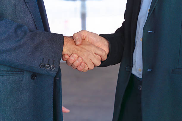 istock Unrecognizable businessmen shaking hands in modern office environment indoors 2218558630