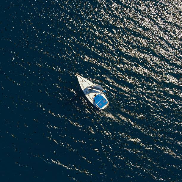 istock Sailboat on shimmering blue water from above. 2218563136