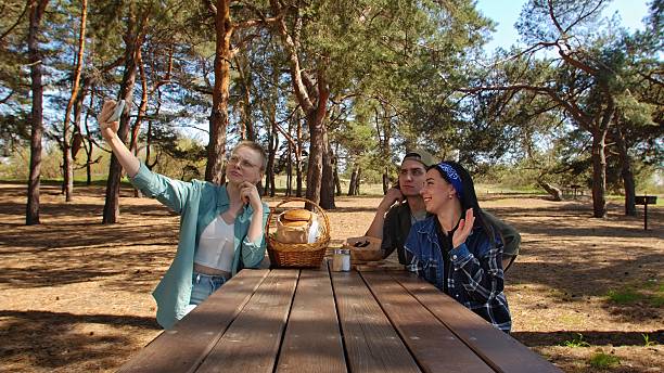 istock Friends Enjoying a Picnic in the Woods While Taking a Selfie 2218569037