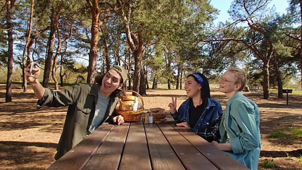 istock Friends Enjoying a Picnic in the Woods While Taking a Selfie 2218569182
