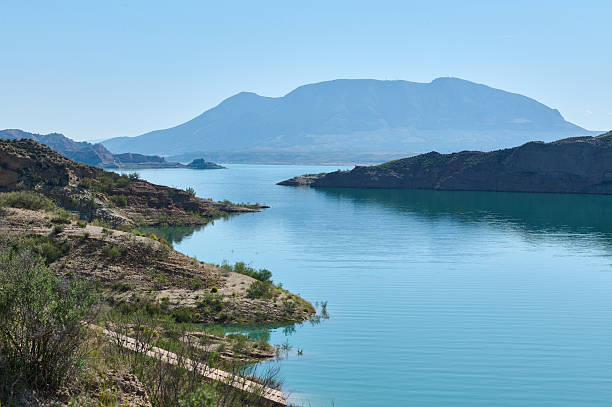 istock Scenic Lake View With Rocky Shorelines and Distant Mountain Under Clear Sky 2218578251
