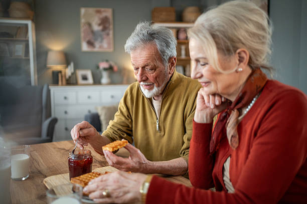 istock Senior couple enjoying waffles with jam at home 2218578424