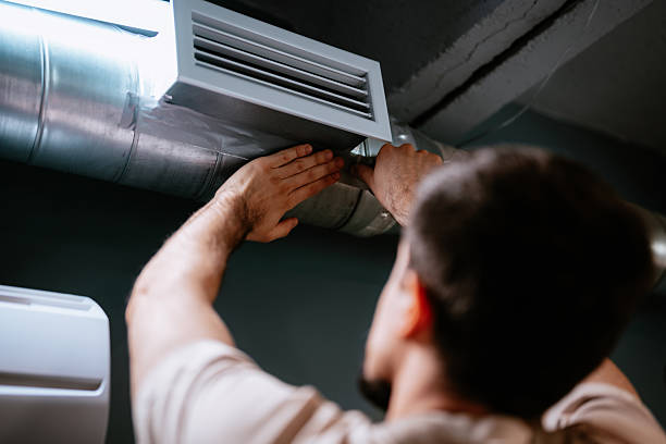 istock Technician repairing air duct in industrial space during daytime while focused on maintenance task 2218578693