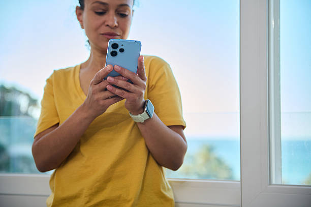 Woman Using Smartphone in Bright Interior With Ocean View