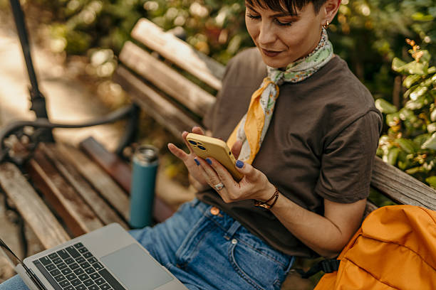 istock Freelancer working remotely from park using laptop and smartphone 2218579502
