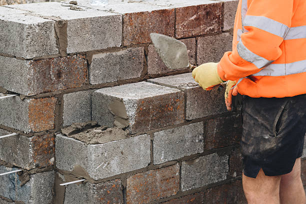istock Close-up of Construction worker laying concrete blocks on building site 2218587133