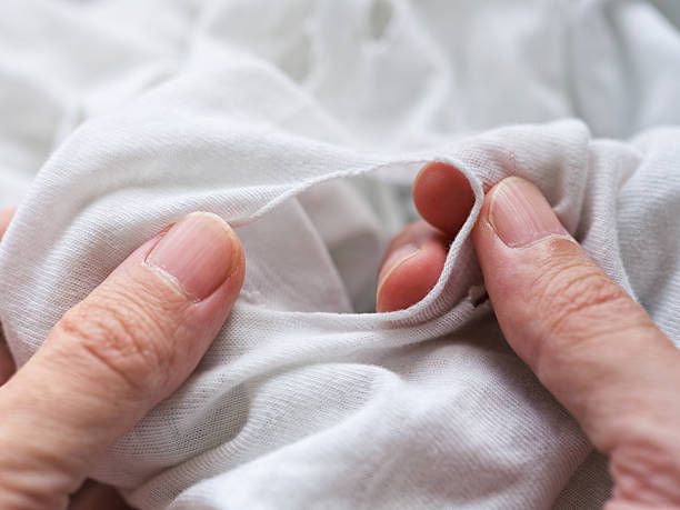 istock A man inspecting a ripped t-shirt 2218587370