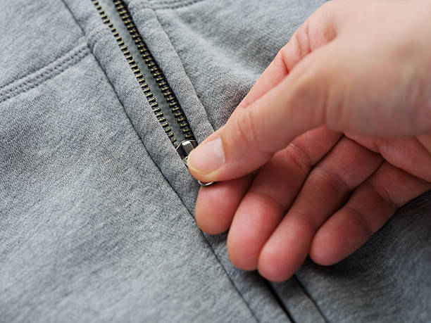 istock A woman unzipping her grey jacket 2218587387