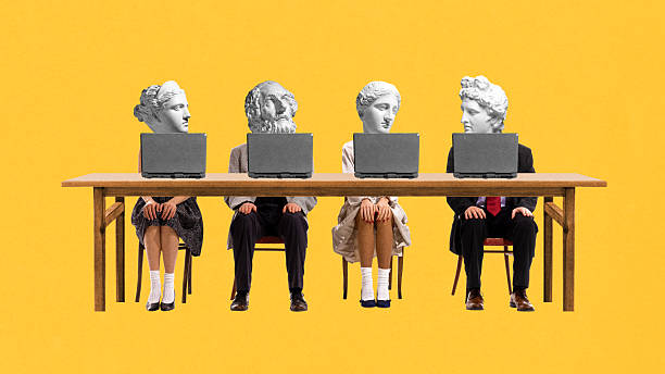 Modern collage. Four bust-headed office workers dressed formally stare at laptop screens around wooden desk against yellow backdrop.