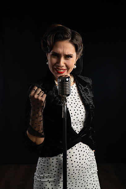 A stylish retro singer passionately performs with a vintage microphone. Classic attire and elegance highlight the performance.