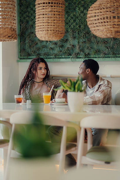 istock Young couple talking and having breakfast in a modern cafe 2218596181