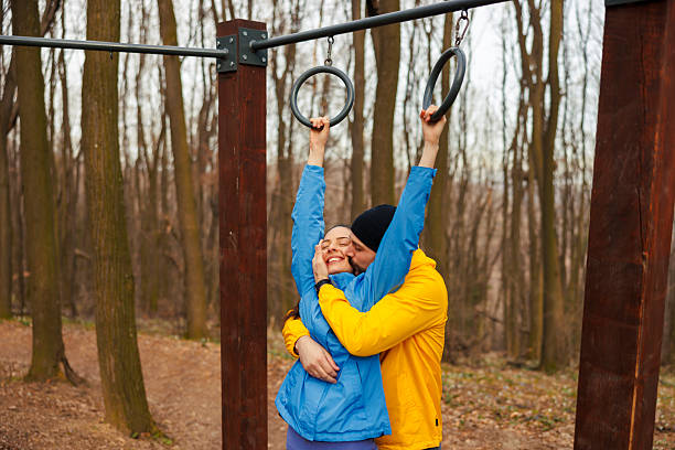 Active fit couple in sportswear hugging and kissing while doing an outdoor workout in nature