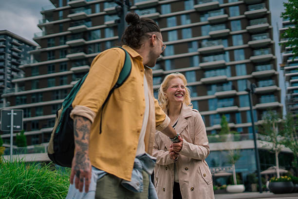 istock A smiling, loving young couple walks hand in hand, surrounded by a modern urban setting. 2218600168