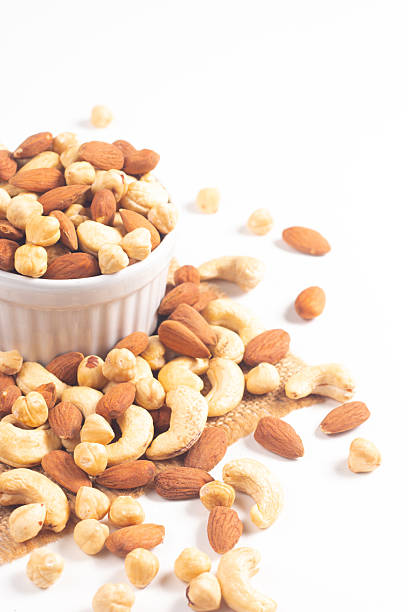 istock Large assortment of nuts in different bowls on stone table. 2218600911