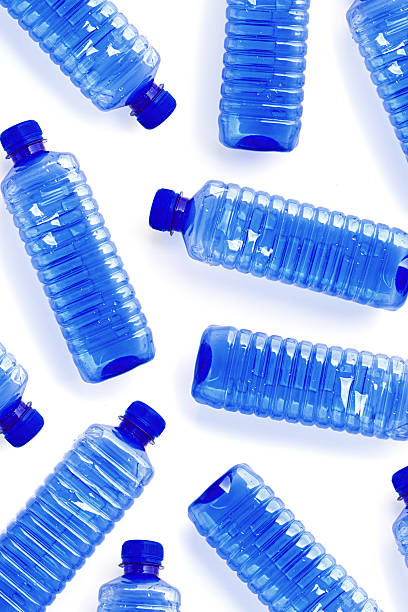 istock Clear single-use plastic water bottles isolated on white background close-up geometric pattern, minimal style, top view of bottled water, Pollution, environmental protection, plastic waste 2218601399