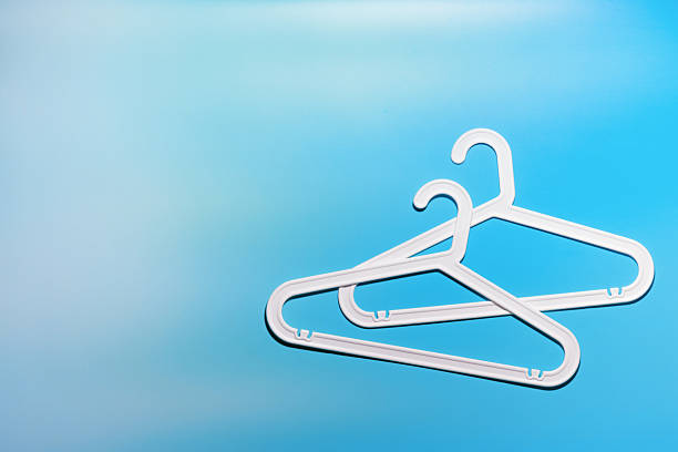 istock Two White Clothes hangers, contemporary minimal composition on vivid blue gradient background, Plastic rack creating modern and minimal aesthetic, top view, flat lay creative photo, copyspace 2218603882