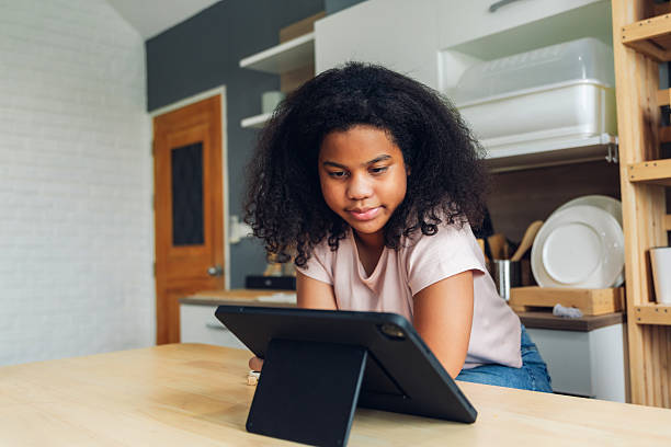 istock E-Learning. Happy Black Woman Student Using Tablet Computer at home. young African American girl using digital tablet at home. work from home 2218604972
